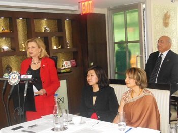 Congresswoman Carolyn Maloney addressing the audience, with Congresswoman Grace Meng and the president of the Association of Indians in America-NY, Ranju Batra, seated, with attorney Ravi Batra standing at the back.