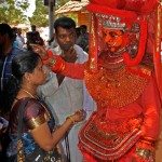 "Theyyam performer praying for a women"