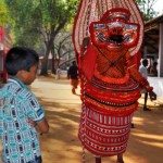 "A boy looking at theyyam"
