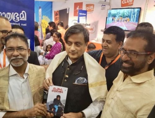 Shashi Tharoor (center) giving a copy of "The Lady Biker" to Shajahan Madampat a the Sharjah International Book Fair on November 9. Looking on is author Thampi Antony.