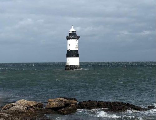 Lighthouse off the coast of Anglesey surrounded by choppy waters